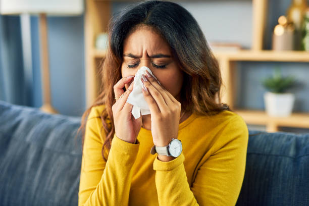 avoiding pollen at home. Girl sneezing