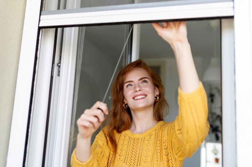 Mujer sonriente junto a la ventana